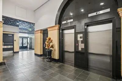 a hallway with two doors and a vase of flowers at Historic Gaslamp Loft with Peloton Bike and Roof Deck in San Diego