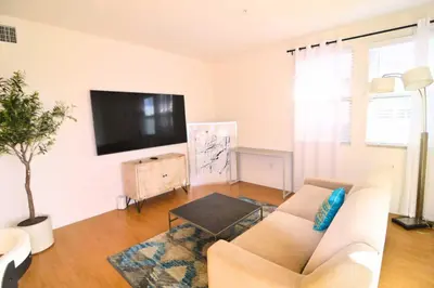 a living room with a couch and a flat screen tv at Stylish 2BR Foothill Escape in Irvine in Lake Forest
