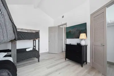 a bedroom with a bunk bed and a desk with a lamp at Coastal Villas Walk to the Beach 3 Homes Villa in San Diego