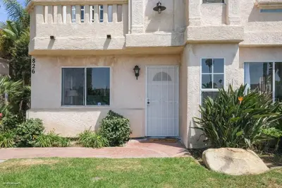 a house with a white door and a yard at Coastal Villas Walk to the Beach 3 Homes Villa in San Diego