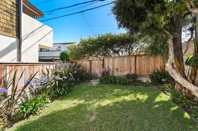 a backyard with a wooden fence and a garden at Laguna Beach Coastal Cottage in Laguna Beach