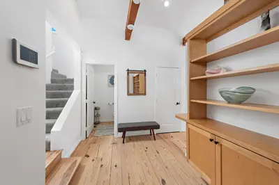 a living room with a stair case and a chair at Laguna Beach Coastal Cottage in Laguna Beach