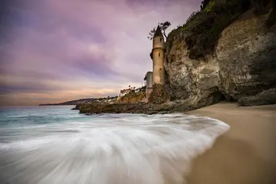 a castle on a cliff next to the ocean at Laguna Beach Coastal Cottage in Laguna Beach