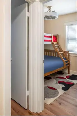 a small bedroom with a bunk bed and a rug at Roswitha's Blue Wave Cottage in San Diego