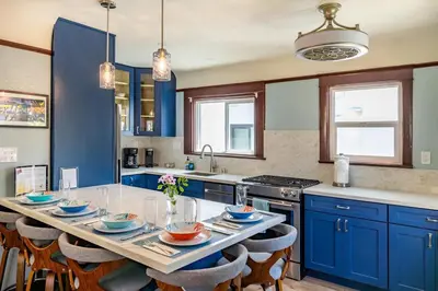a kitchen with blue cabinets and a table with chairs at Roswitha's Blue Wave Cottage in San Diego