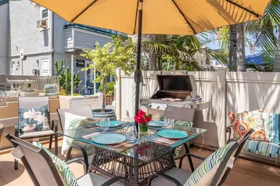 a table and chairs with an umbrella on a patio at Roswitha's Blue Wave Cottage in San Diego