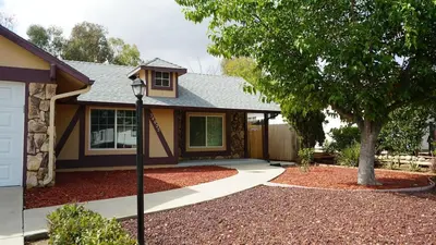 a house with a tree in front of it at Cozy 3-bedroom residential home in Wildomar, CA in Wildomar