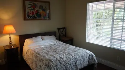 a bedroom with a bed and a lamp and a window at Cozy 3-bedroom residential home in Wildomar, CA in Wildomar