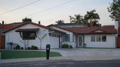 a white house with a parking meter in front of it at Terrific 3-bedroom house with AC in Oceanside in Oceanside
