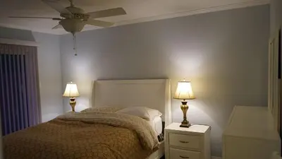 a bedroom with a bed with two lamps and a ceiling fan at Terrific 3-bedroom house with AC in Oceanside in Oceanside