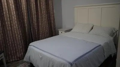 a bedroom with a bed and a window with curtains at Terrific 3-bedroom house with AC in Oceanside in Oceanside