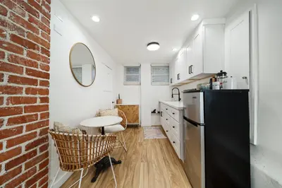 a kitchen with a black refrigerator and a brick wall at Boho Little Italy Studio with Patio in San Diego