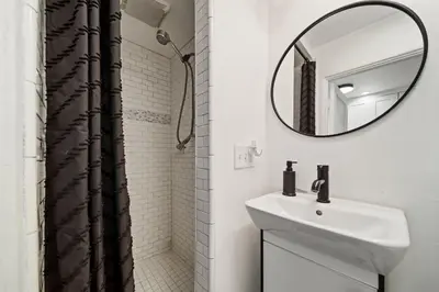 a white bathroom with a sink and a mirror at Boho Little Italy Studio with Patio in San Diego