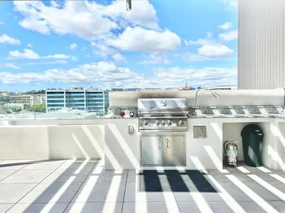 a grill on a balcony with a view of a building at Urban Oasis w Rooftop Views Heart of San Diego in San Diego