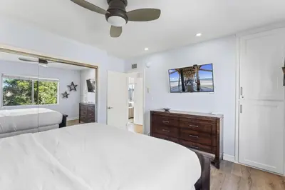a white bedroom with a bed and a ceiling fan at Hideaway ALL Walk to the Beach Downtown AC in San Clemente