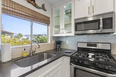 a kitchen with a sink and a stove and a window at Hideaway C Walk to the beach Downtown AC in San Clemente