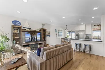 a living room with a couch and a kitchen at Hideaway C Walk to the beach Downtown AC in San Clemente