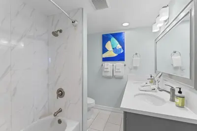 a white bathroom with a shower and a sink at Hideaway C Walk to the beach Downtown AC in San Clemente