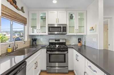a kitchen with a stove and a microwave at Hideaway C Walk to the beach Downtown AC in San Clemente