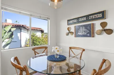 a dining room with a glass table and chairs at Hideaway B Walk to the beach Downtown AC in San Clemente
