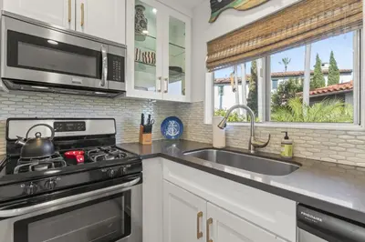 a kitchen with a stove and a sink and a microwave at Hideaway B Walk to the beach Downtown AC in San Clemente