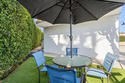 a table and chairs with an umbrella on a patio at Hideaway B Walk to the beach Downtown AC in San Clemente