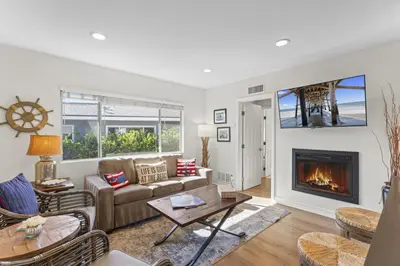 a living room with a couch and a fireplace at Hideaway B Walk to the beach Downtown AC in San Clemente