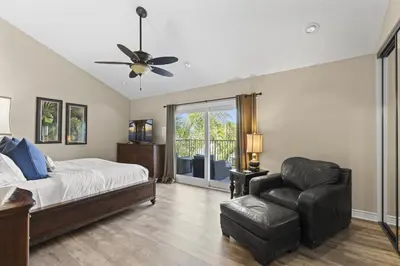 a bedroom with a bed and a chair and a ceiling fan at Coastal Duo Steps to Ole Hanson Casino and the beach in San Clemente