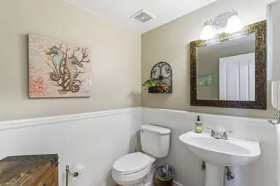 a bathroom with a sink and a toilet and a mirror at Coastal Duo Steps to Ole Hanson Casino and the beach in San Clemente