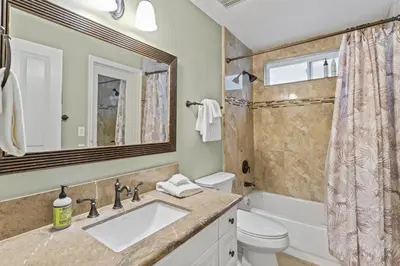 a bathroom with a sink and a toilet and a mirror at Coastal Duo Steps to Ole Hanson Casino and the beach in San Clemente