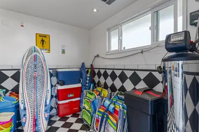 a room with a surfboard and other items in it at Coastal Duo Steps to Ole Hanson Casino and the beach in San Clemente
