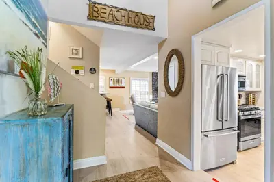 a kitchen with a refrigerator and a living room at 4BR Beach Condo Kids Hideaway Walk to Beach Casino Ole Hanson in San Clemente