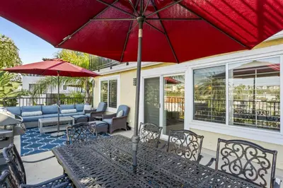a patio with a table with a red umbrella at 4BR Beach Condo Kids Hideaway Walk to Beach Casino Ole Hanson in San Clemente