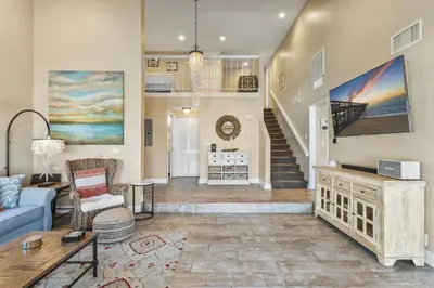 a living room with a blue couch and a staircase at Walk to the beach and Ole Hanson Casino Wedding Venues in San Clemente