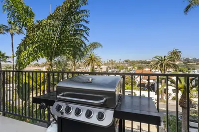 a grill on a table on a balcony with palm trees at Bright 3BR Beach Condo Near Casino and Ole Hanson in San Clemente