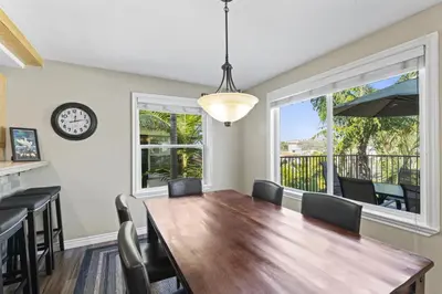 a dining room with a table and chairs and a clock at Bright 3BR Beach Condo Near Casino and Ole Hanson in San Clemente
