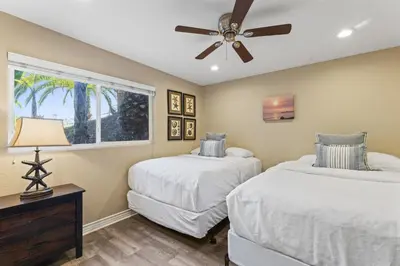 two beds in a bedroom with a ceiling fan at Bright 3BR Beach Condo Near Casino and Ole Hanson in San Clemente