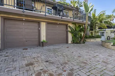 two garage doors on the side of a house at Tropical 2BR Retreat Walk to Beach Wedding Venues Large Deck in San Clemente