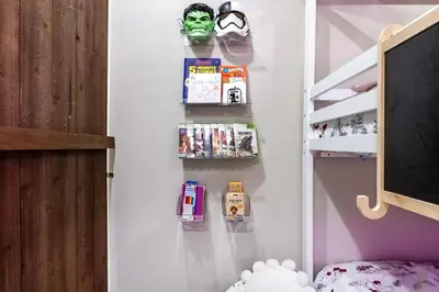 a childs room with a shelf with books and a mask at Chula Vista 3BR with Children's Playroom, Pool, Park and Sleeps 9 in Chula Vista