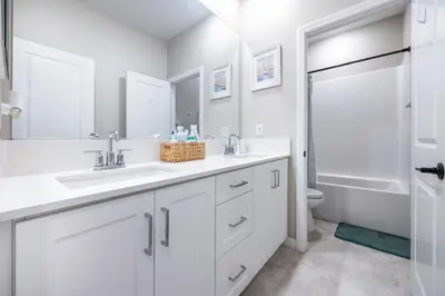 a white bathroom with two sinks and a toilet at Chula Vista 3BR with Children's Playroom, Pool, Park and Sleeps 9 in Chula Vista