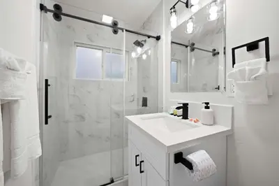 a white bathroom with a sink and a shower at Explore North Park Chic 2br with Fire Pit Sleeps 6 in San Diego