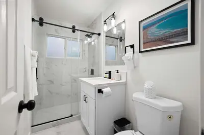 a white bathroom with a shower and a toilet at Explore North Park Chic 2br with Fire Pit Sleeps 6 in San Diego