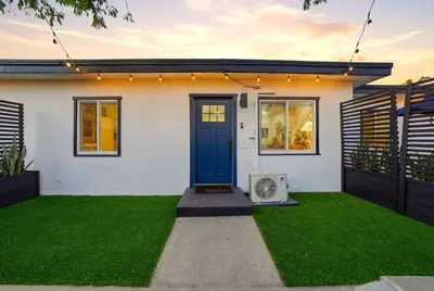 a house with a blue door and a green lawn at Explore North Park Chic 2br with Fire Pit Sleeps 6 in San Diego