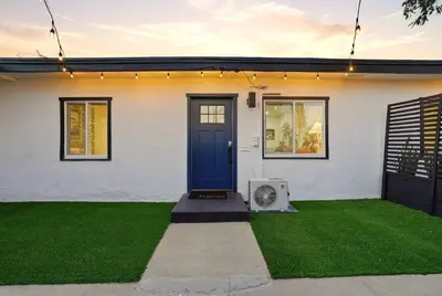 a house with a blue door and a lawn at Stylish 2BR SD Retreat Firepit plus Outdoor Lounge in San Diego
