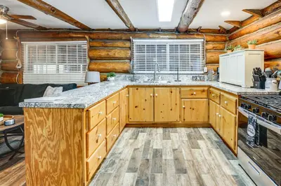 a log cabin kitchen with wooden cabinets and a stove at MTB Base Camp! Rustic Cabin By Mt Laguna Trails in Mount Laguna