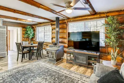 a living room with a fireplace and a television and a table at MTB Base Camp! Rustic Cabin By Mt Laguna Trails in Mount Laguna