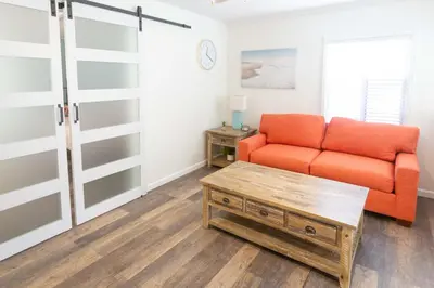 a living room with an orange couch and a coffee table at Beach to Bay The Ultimate SD location in San Diego
