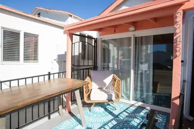 a balcony with a wooden table and a chair at Beach to Bay The Ultimate SD location in San Diego