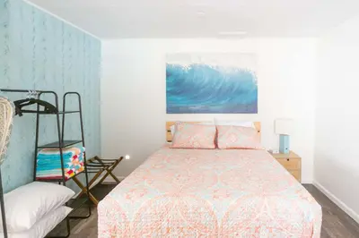 a bedroom with a bed and a painting on the wall at Beach to Bay The Ultimate SD location in San Diego