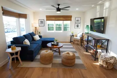 a living room with a blue couch and a table at Sunset View home 2 min walk to beach parking in San Diego